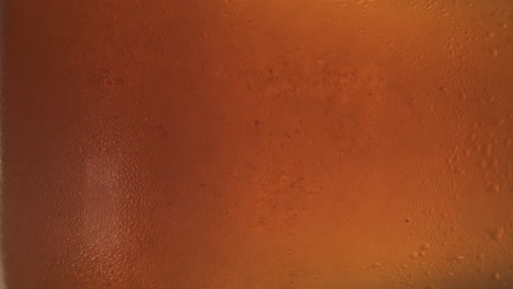 primer plano de un vaso giratorio con cerveza gaseosa fría
