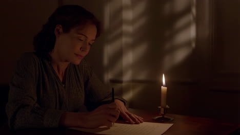 woman writing by candlelight
