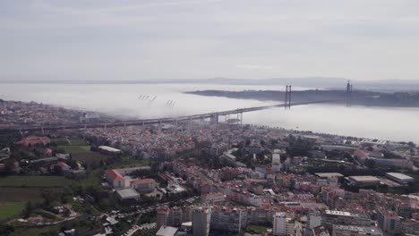 establish scenic bridge in lisbon covered in moody clouds, aerial skyline