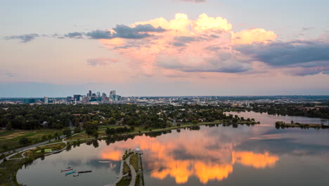 aerial hyperlapse of denver's sloan lake with denver's downtown skyscrapers off in the distance