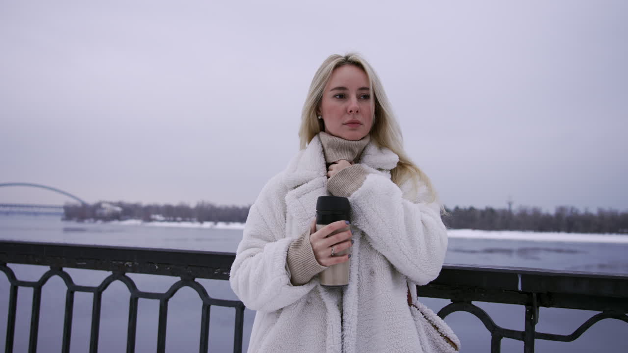 뜨거운 테르모스를 들고 있는 금발 소녀