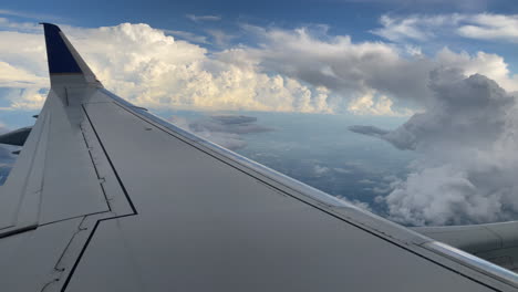 airplane pov flying high through large puffy clouds