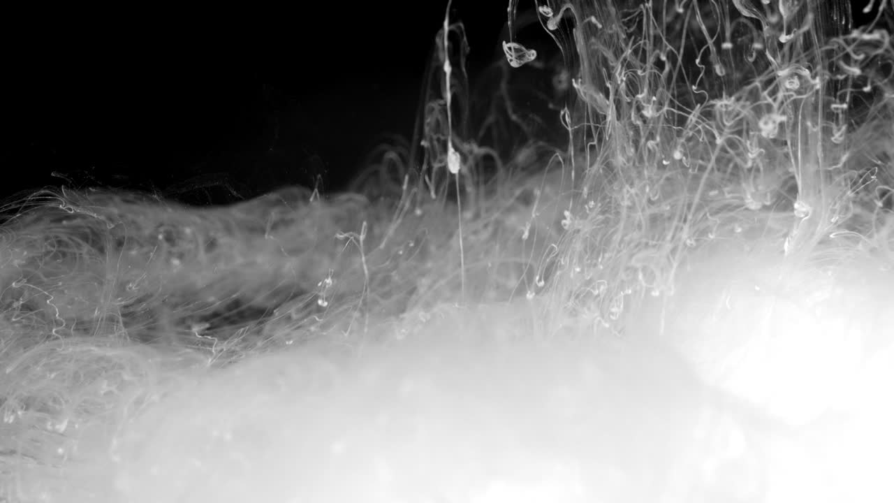 efecto de tinta blanca en agua filmado sobre fondo negro