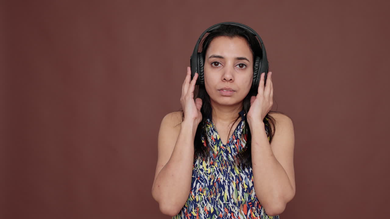 Indian woman having fun listening to music on headphones