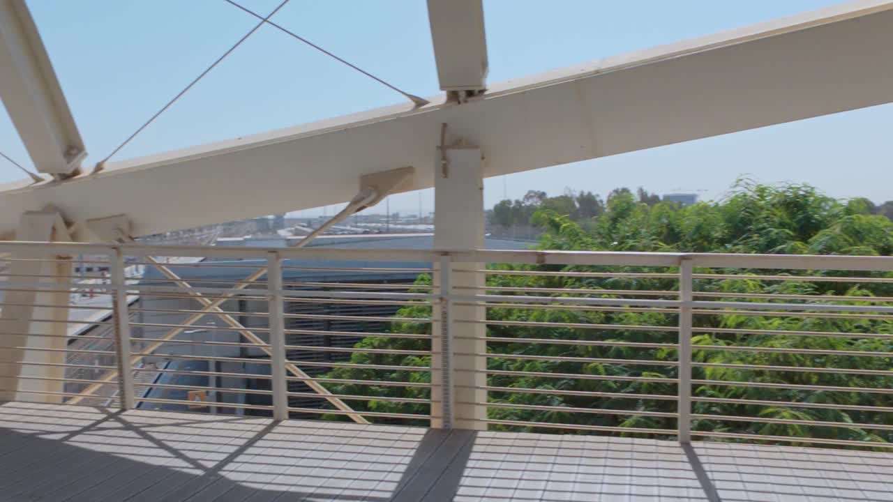 Architectural View of a Modern Pedestrian Bridge with Lush Green Trees