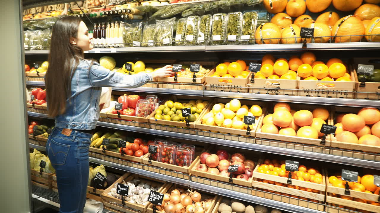 woman shopping for fruits and vegetables in produce department of a grocery store/supermarket