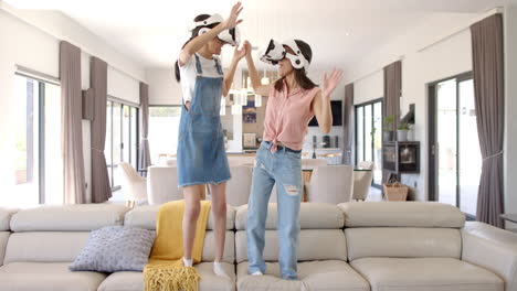 teenage girls wearing vr headsets, dancing on couch, having fun together