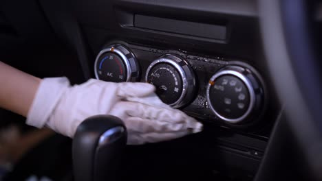cerca de guante blanco rociado y limpiado a mano superficie de control del aire acondicionado del automóvil, desinfección, industria de cuidado del automóvil, detener la propagación del virus de la corona covid-19, toallas desinfectantes, a menudo panel de instrumentos táctil