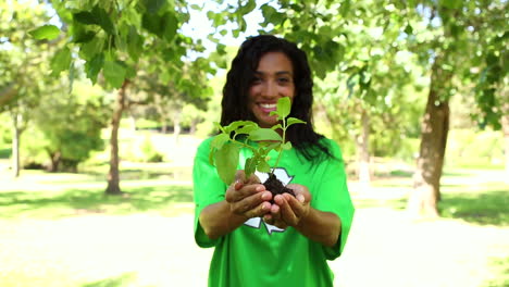 activista ambiental feliz sosteniendo un arbusto