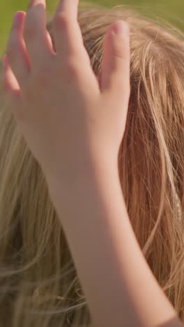 a tender moment where a child's hand is seen touching his mother's hair, while another child appears blurred in the background. the focus is on the intimate connection between mother and child