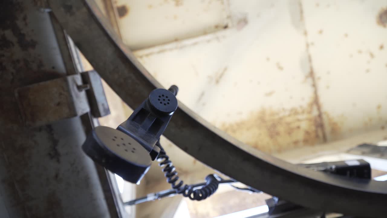 Army radio phone hanging. Hand in the frame stabilizing. AN-PRC radio and handset