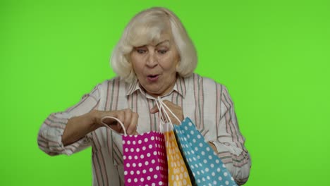 abuela mayor mostrando venta porcentaje de descuento inscripción publicitaria de la bolsa de compras