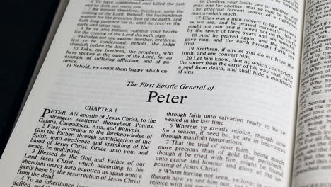 close up shot of bible page turning to the book of first peter