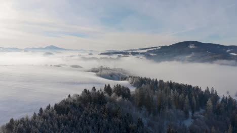 Breathtaking-flight-over-snowy-winter-landscape-with-clouds-and-mountains