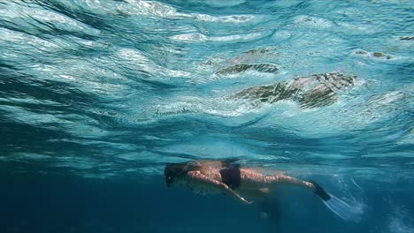 Mädchen-Schnorchelt-über-Dem-Riff-Im-Klaren,-Blauen-Meerwasser,-Zeitlupe