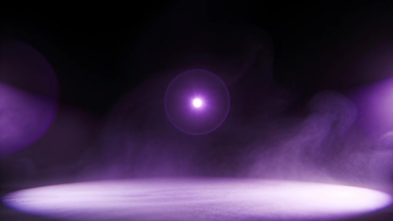 Cirkulær lilla pøl dannes på scenen, tåge driver, og en kugle lyser op med lens flares for glød.