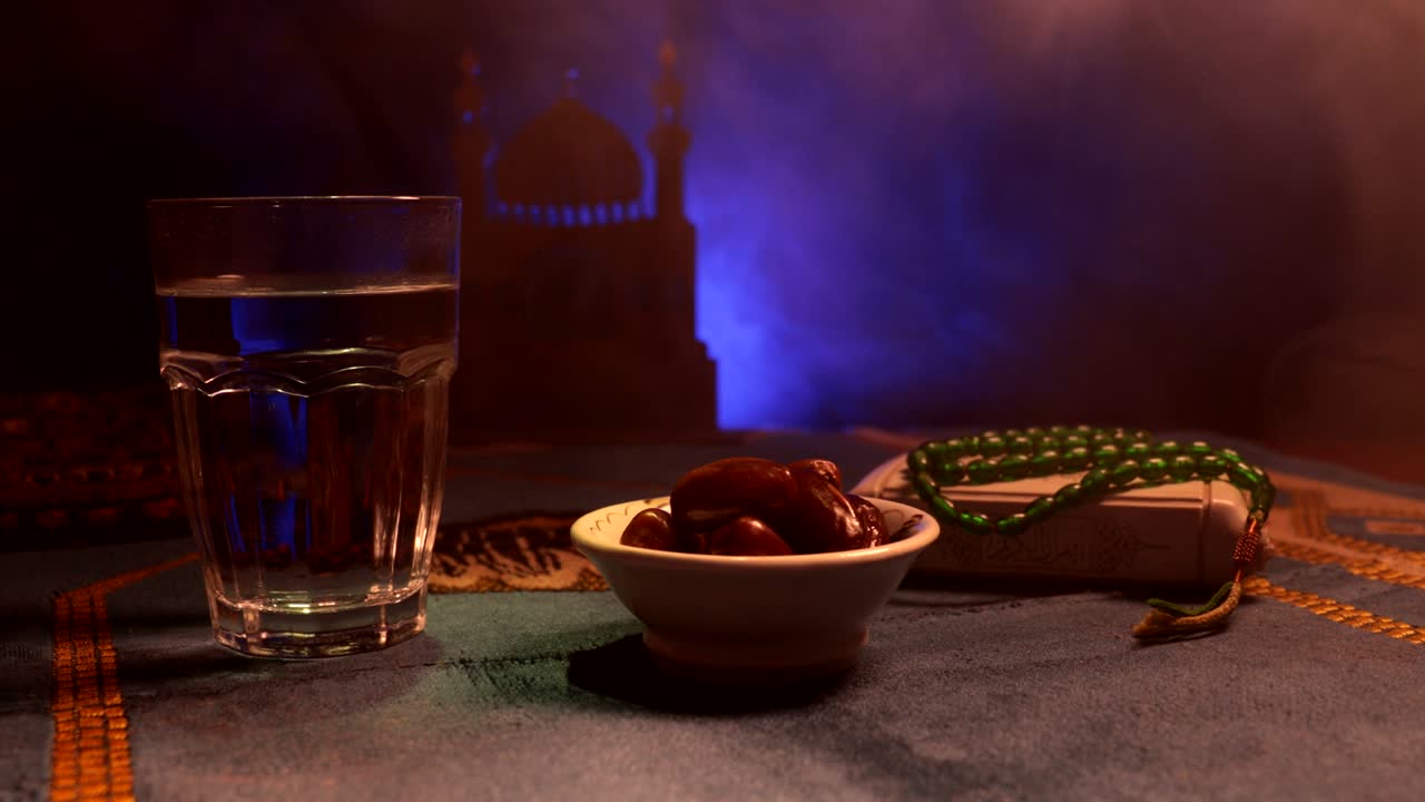 agua y dátiles. el iftar es la comida de la noche. vista deslizante de la decoración vacaciones de ramadán kareem. tarjeta de felicitación festiva, invitación para el mes sagrado musulmán ramadán kareem. fondo oscuro. enfoque selectivo