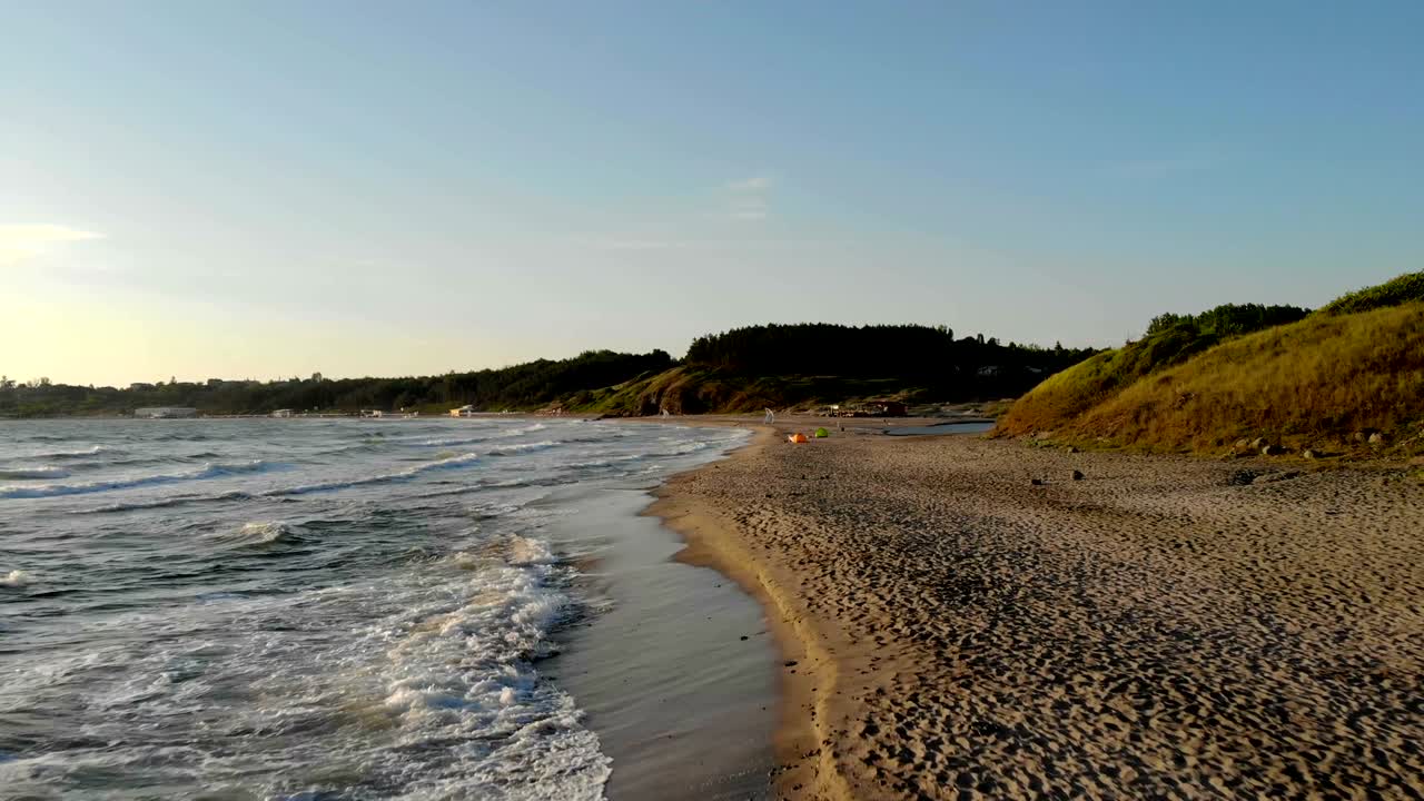 Waves crashing on sand at sunrise during vacation at Bulgaria.
