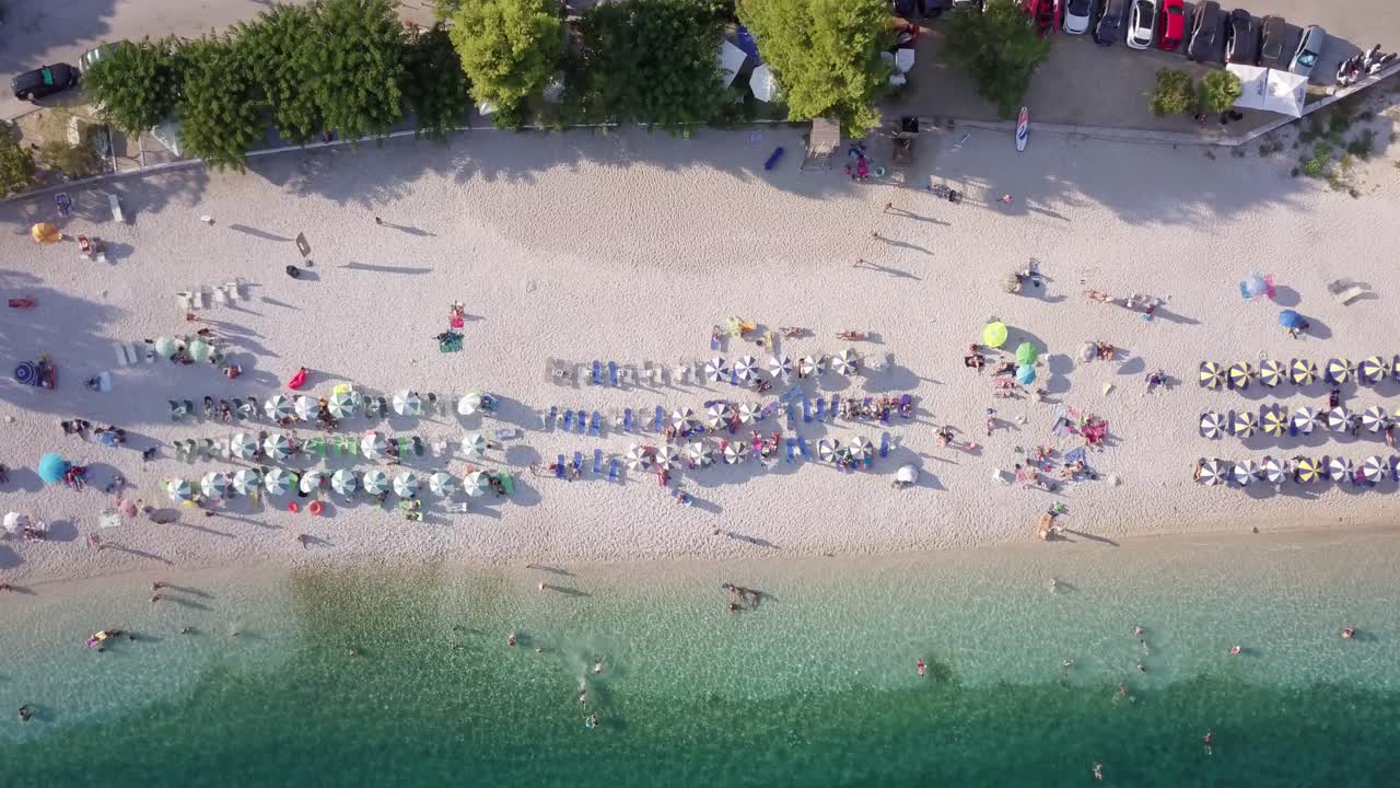 Flying above a beautiful and organized beach, top view aerial