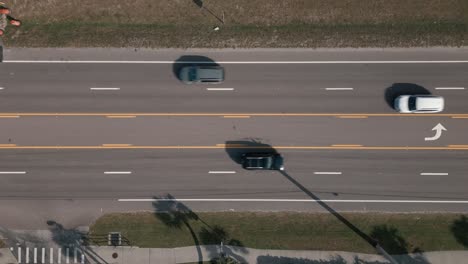 top-down-aerial-shot-of-a-two-way-5-lane-road-with-traffic-moving-in-both-directions-on-a-sunny-day