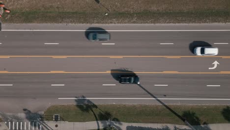 Toma-Aérea-De-Arriba-Hacia-Abajo-De-Una-Carretera-De-5-Carriles-De-Dos-Vías-Con-Tráfico-Moviéndose-En-Ambas-Direcciones-En-Un-Día-Soleado