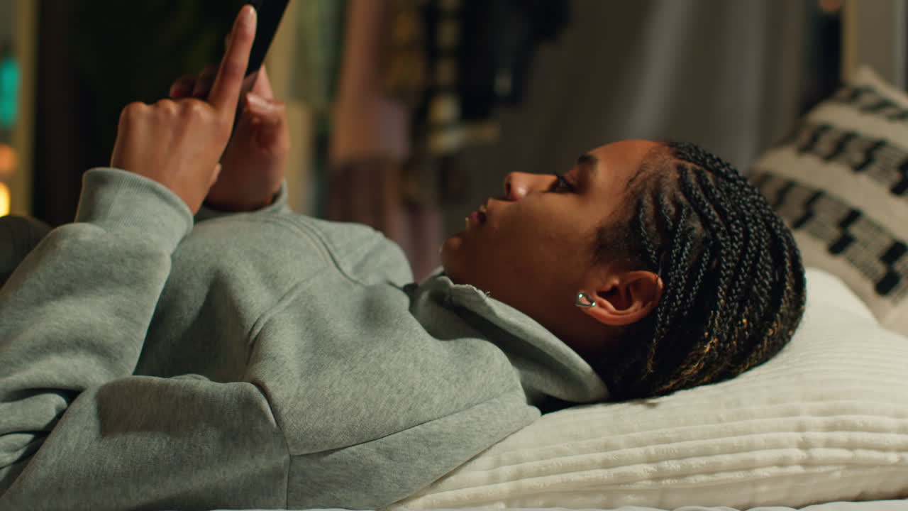 Teenager using phone in bed at night