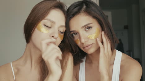 two women relaxing with gold eye patches