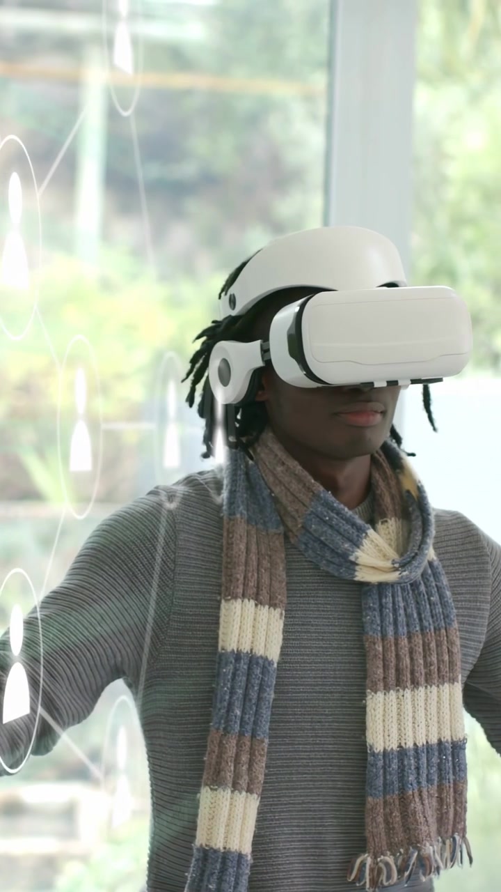 Vertikal video: Mand med VR-headset drejer og strækker armene ud, mens cirkler dukker op, og han interagerer med teknologi.