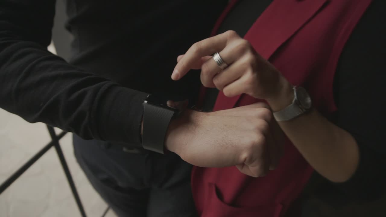 Couple interacting with smartwatches