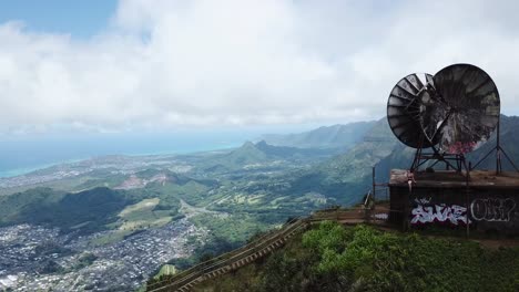 drone 4000ft up in the air in oahu getting a shot of a satellite on top of the stairway to heaven, a girl is sitting on the satellite as the shot reveals a different angle