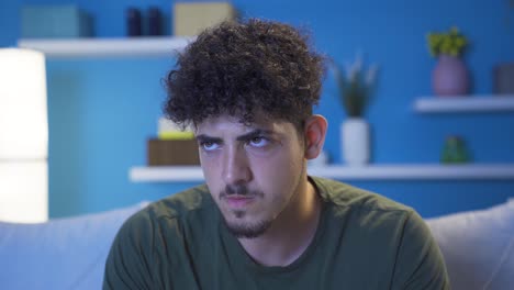 Close-up-of-angry-and-aggressive-young-man-at-night-at-home.