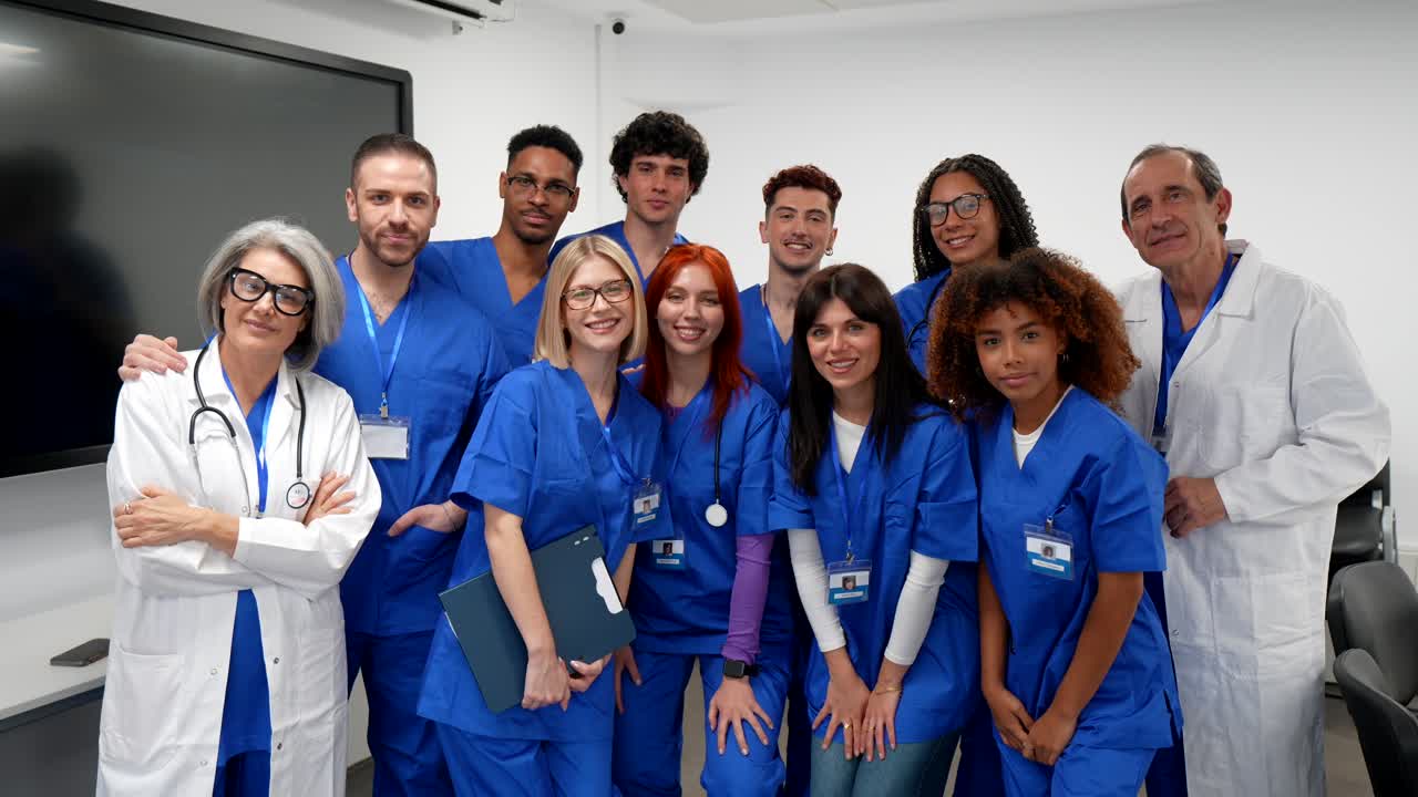 Gruppo eterogeneo di studenti e professionisti medici in posa in un'aula.