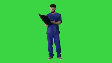 what is that? male doctor examines x-ray picture of a human brain on a green screen, chroma key