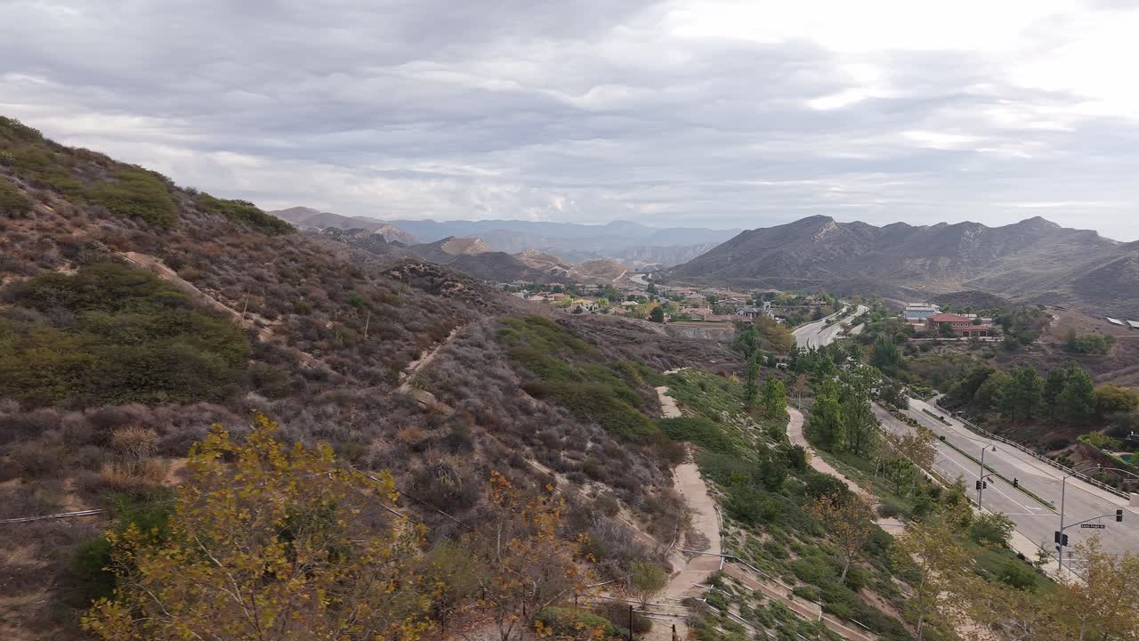 Panning drone shot reveals Simi Valley’s open terrain, with its patchwork of homes, parks, and rugged mountain backdrops