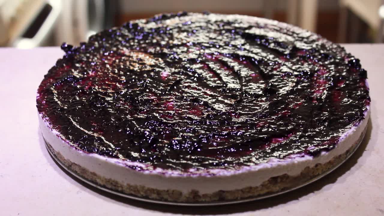 Cheesecake vegana cruda fatta in casa con copertura ai mirtilli sul piano di lavoro della cucina