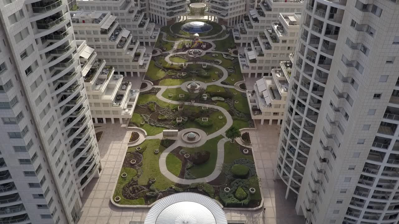 vista aérea de un complejo residencial moderno con un exuberante jardín en el patio