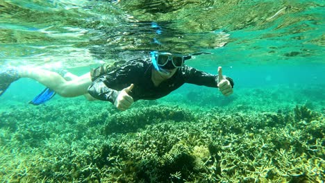 caucasian enjoying snorkeling,exploring the huge stony corals and the the clear turquoise water on cebu, philippines