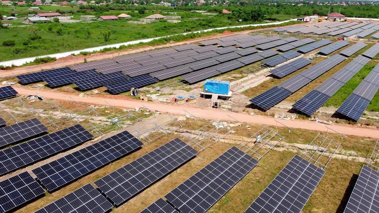 vista aérea de la granja solar en construcción que muestra el progreso de la colocación de cables, carretes, trincheras, paneles nuevos y polvorientos