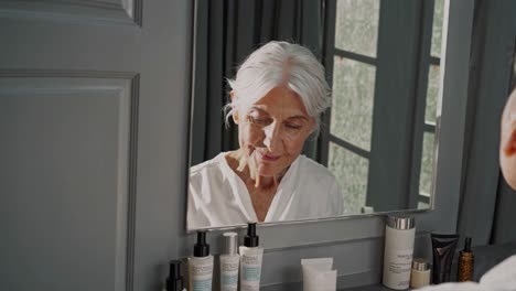 senior woman applying skincare