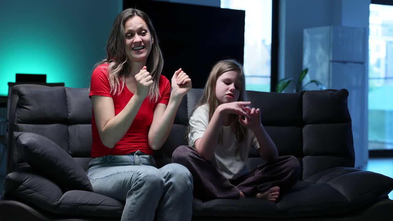 Mor og datter danser i sofaen