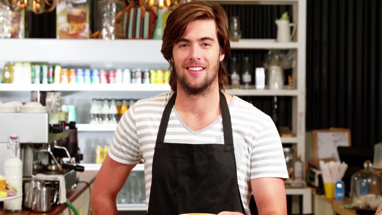 Mannlig kelner holder en kopp kaffe