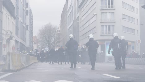 riot police hold the line as tear gas is fired back at protest turns violent - brussels, belgium