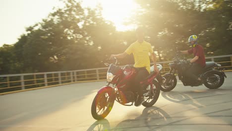 guy instructor in a yellow t-shirt trains his student to ride a motorcycle. check-in of motorcyclists in sunny weather at the training ground in a motorcycle school