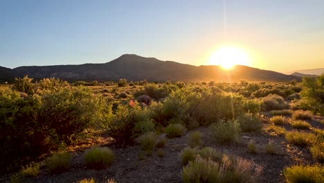 la puesta de sol detrás de una colina desierta