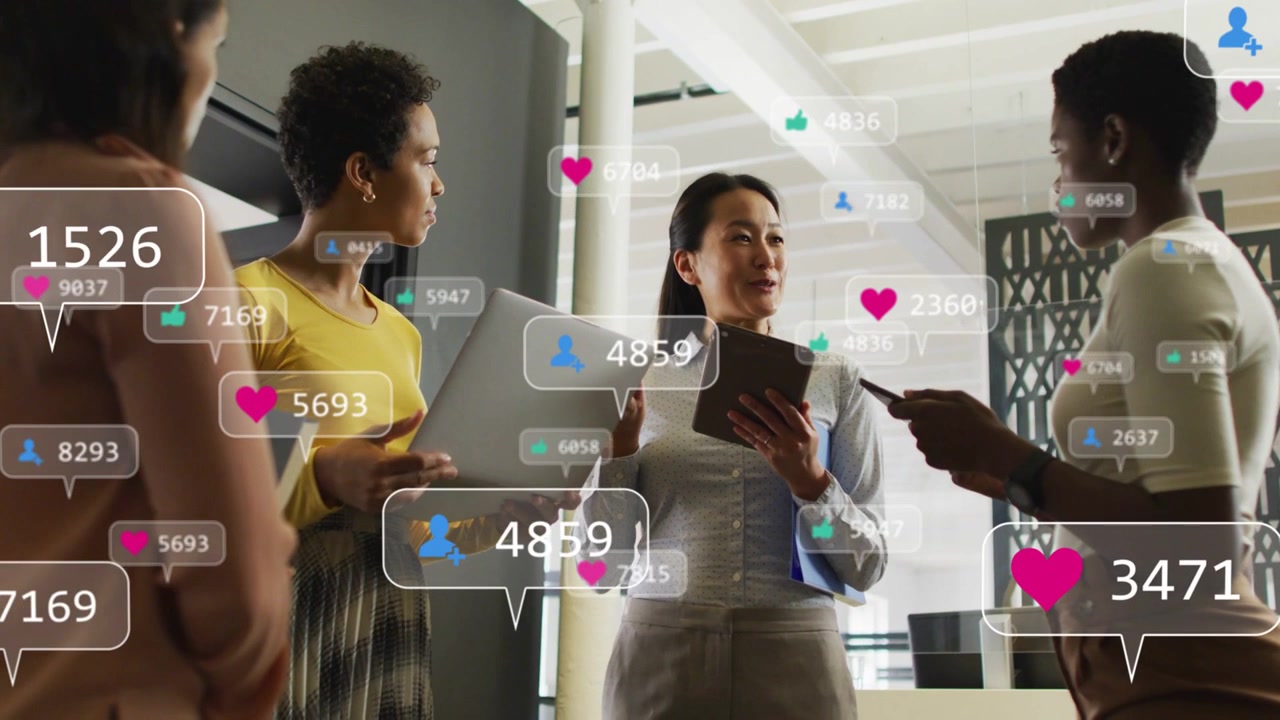 Marketing meeting open-plan, center lead gesturing tablet causing growing like icons showing growth