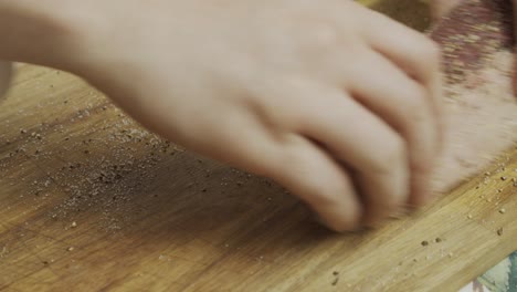 在切割板上添加香料到肉牛排上