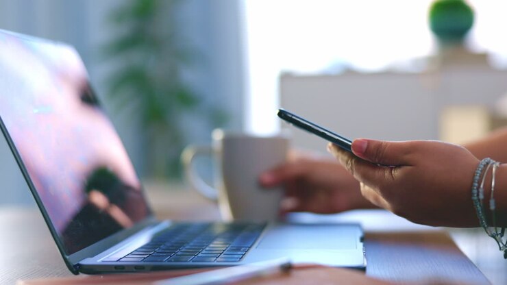 Mani, telefono e laptop per lavoro a distanza