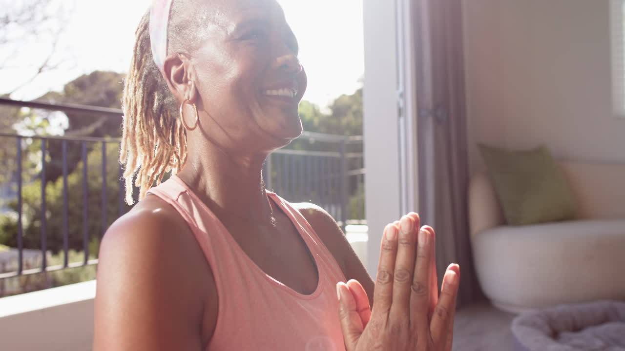 African American senior woman sitting indoors, looking away with smile