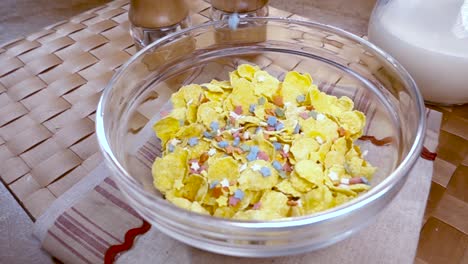 flocos de maíz amarillos crujientes en el cuenco para la mañana un delicioso desayuno con leche. cámara lenta con toma de seguimiento de rotación.