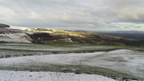 Snowy-rural-winter-valley-countryside-aerial-agricultural-highlands-landscape-orbit-right